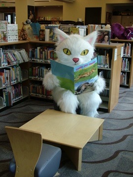 image of a giant white cat reading a green book