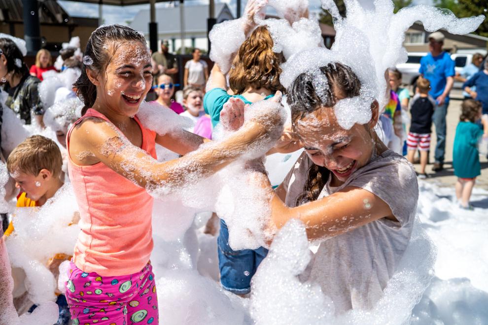 two young people play in bubbly foam 