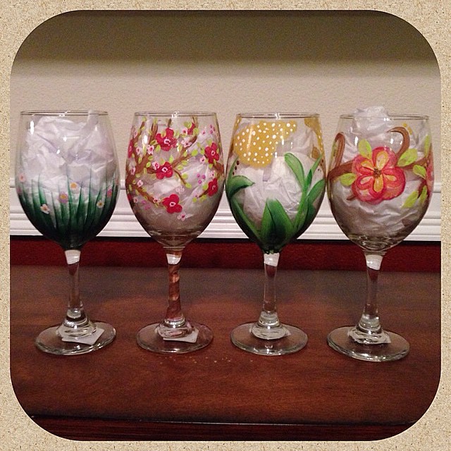 four wine glasses hand painted with floral designs blue red green orange