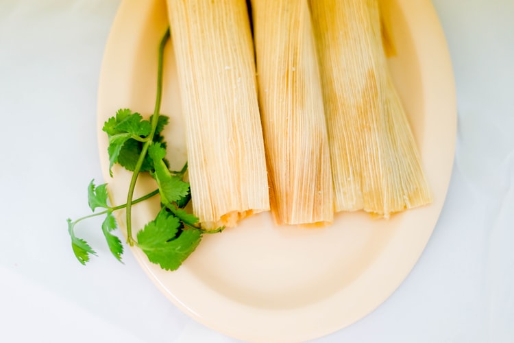 A plate with tamales and cilantro