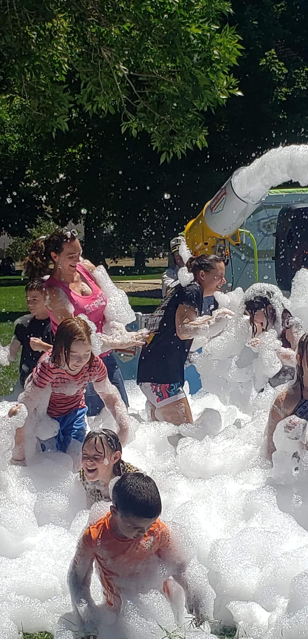 Families playing in foam bubbles