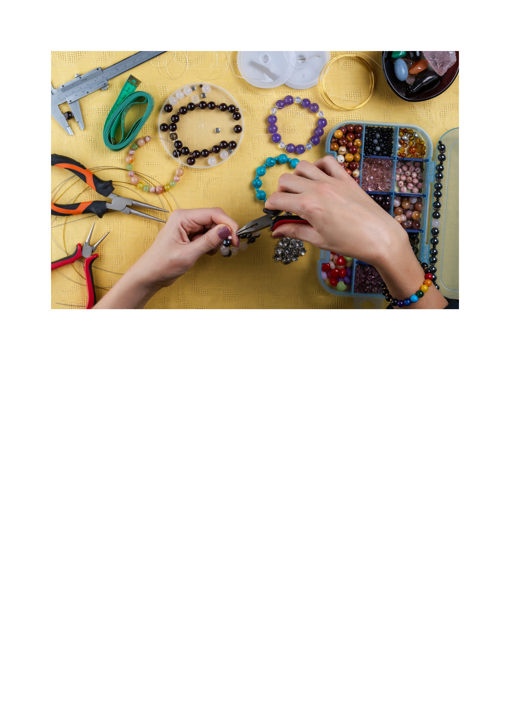 Person designing jewelry using beads and jewelry tool