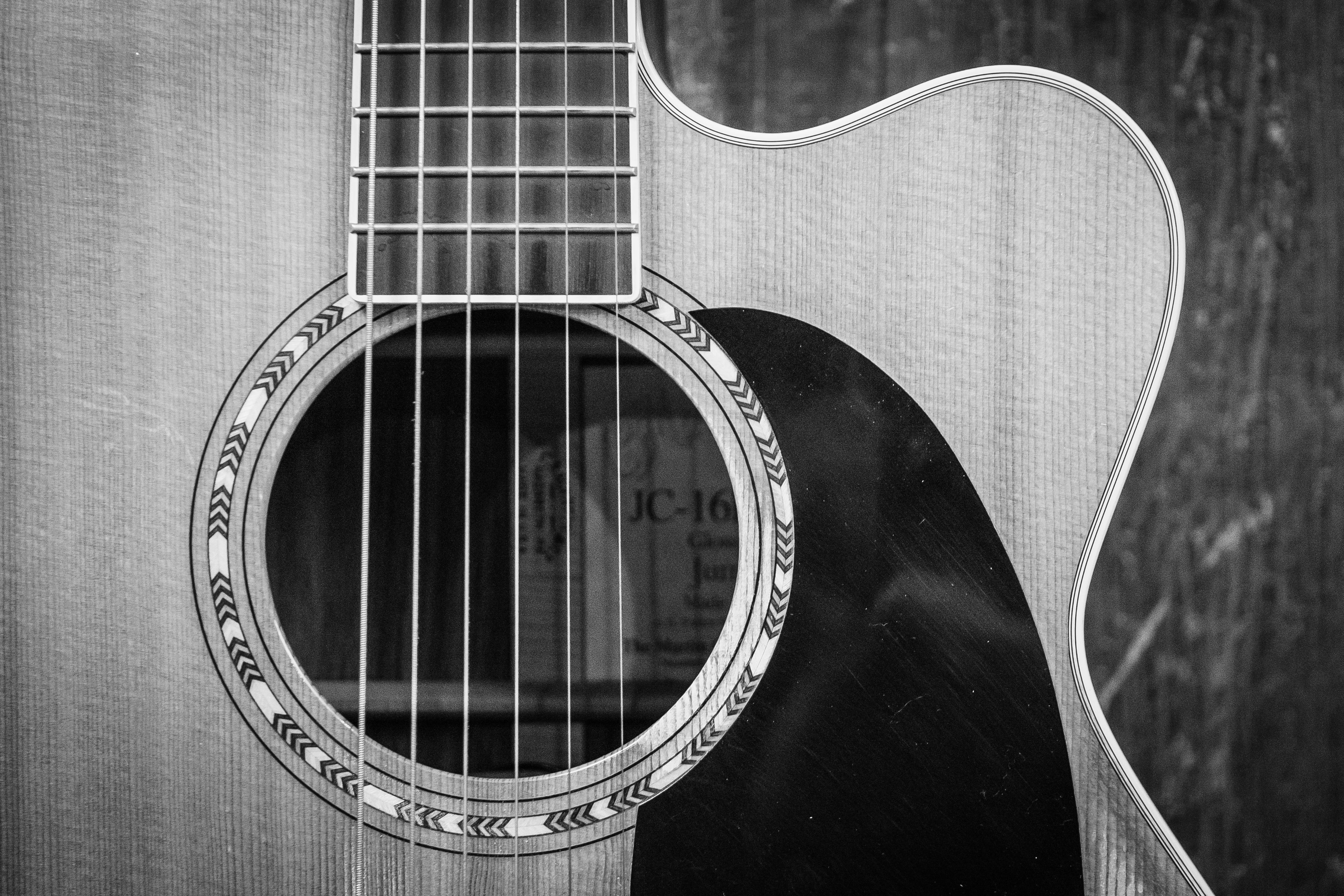 A close up of a guitar in black and white