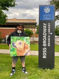 Patrick Kane McGregor holding a piece of his artwork outside the Ross-Broadway Branch Librarty