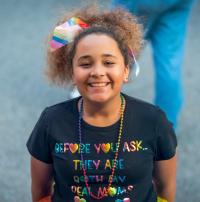 A child wearing a shirt that says "they're both my moms"