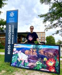 Grow Love holds a piece of her artwork outside the Ross-Broadway Branch Library