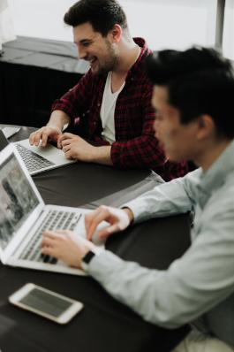 Two people sitting at a table working on their laptops. Photo by Priscilla Du Preez on Unsplash