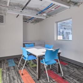 study room with table and four blue chairs