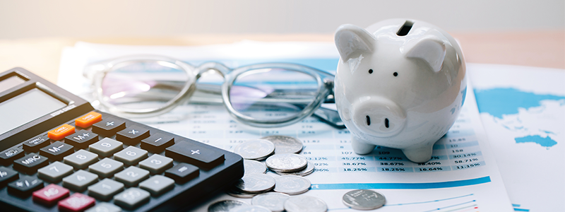 Piggy bank, coins, and calculator on desk